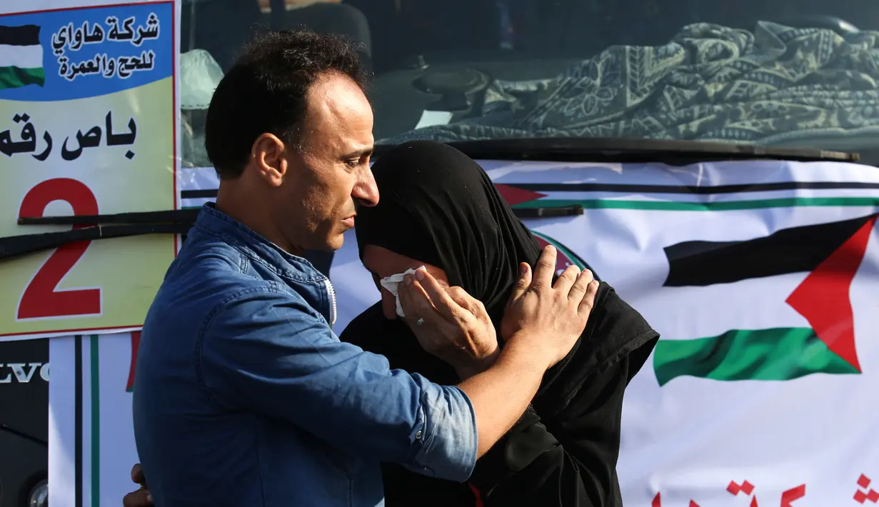 Calon jemaah haji Palestina memeluk kerabatnya sebelum saat akan berangkat menuju Makkah di perbatasan Jalur Gaza dengan Mesir, Rafah, Kamis (25/7/2019). Arab Saudi memberikan tujuh ribu kuota jemaah per tahun bagi warga Palestina. (SAID KHATIB/AFP)