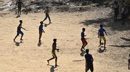 Anak-anak pengungsi Rohingya bermain sepak bola di kamp pengungsi Kutupalong di Ukhia (22/3/2022). Ratusan ribu orang Rohingya melarikan diri dari Myanmar setelah tindakan keras tahun 2017, yang menjadi subjek kasus genosida di pengadilan tertinggi PBB di Den Haag. (AFP/Munir Uz Zaman)