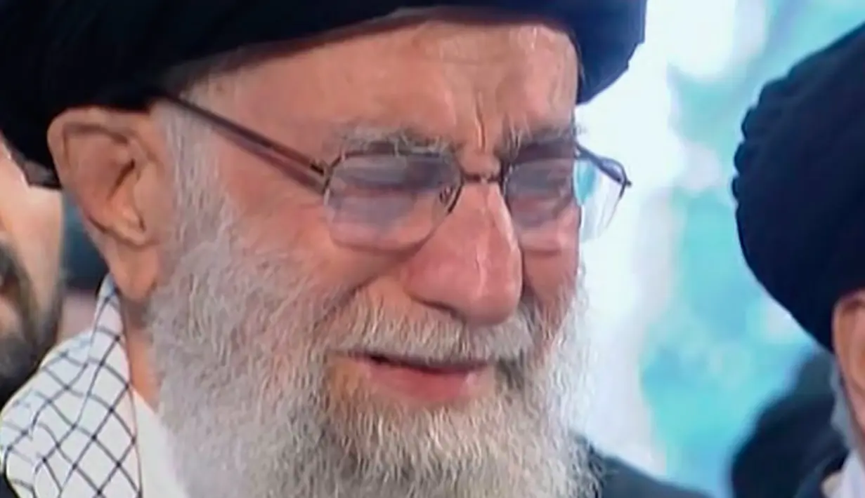 Pemimpin Tertinggi Iran, Ayatollah Ali Khamenei menangis saat berdoa atas jenazah Mayor Jenderal Qassem Soleimani di Universitas Teheran, Senin (6/1/2020). Qassem Soleimani tewas setelah menjadi target serangan drone AS di Bandara Internasional Baghdad beberapa hari lalu. (Iran Press TV via AP)