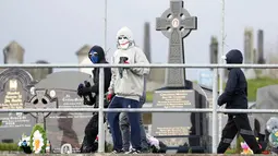 Foto-foto menunjukkan empat pemuda di daerah Creggan yang sebagian besar berhaluan nasionalis Irlandia melemparkan bom molotov ke sebuah kendaraan lapis baja polisi, yang dilalap api di satu sisi. (AP Photo/Peter Morrison)
