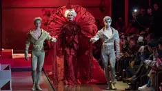 Model lansia Carmen Dell'Orefice ditemani dua pria berpakaian serba keemasan berjalan di runway Couture Fashion Week, Paris, 25 Januari 2017. Model 85 tahun itu tampil bak bintang menggunakan gaun koleksi desainer Guo Pei. (AP Photo/Zacharie Scheurer)