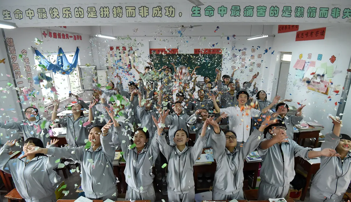 Para siswa melemparkan sobekan kertas melepaskan stres sebelum ujian masuk perguruan tinggi di sebuah sekolah tinggi di Handan, Provinsi Hebei China utara, (24/5). Cara unik ini dilakukan agar para siswanya lebih rileks menghadapi ujian. (AFP PHOTO/STR)