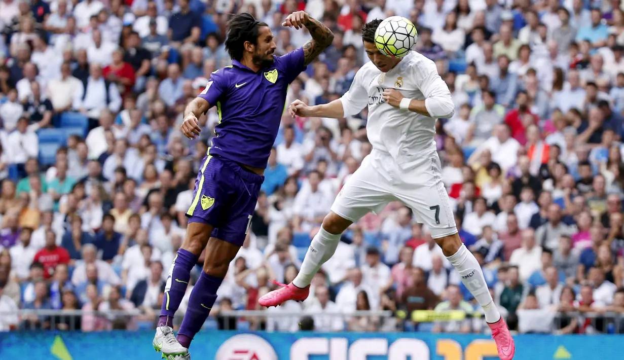 Gelandang Real Madrid, Cristiano Ronaldo (kanan) menyudul bola dari kawalan bek Malaga, Marcos Angeleri pada Liga Spanyol di Santiago Bernabeu, Madrid, (26/9/2015). Madrid bermain imbang atas malaga dengan skor 0-0. (REUTERS/Juan Medina)