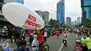 Sejumlah peserta berfoto di depan balon udara saat mengikuti aksi damai 'Kita Indonesia' di Bundaran HI, Jakarta, Minggu (4/12). Masayarakat yang memadati kawasan tersebut juga datang untuk mengikuti parade kebudayaan. (Liputan6.com/Angga Yuniar)