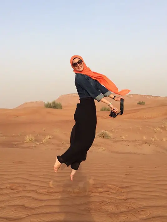 Citra Kirana di padang pasir Dubai dalam rangkaiannya melakukan umroh sekaligus liburan. Pose melompat ini seakan menunjukkan Citra Kirana terbang. (via instagram/@citraciki)