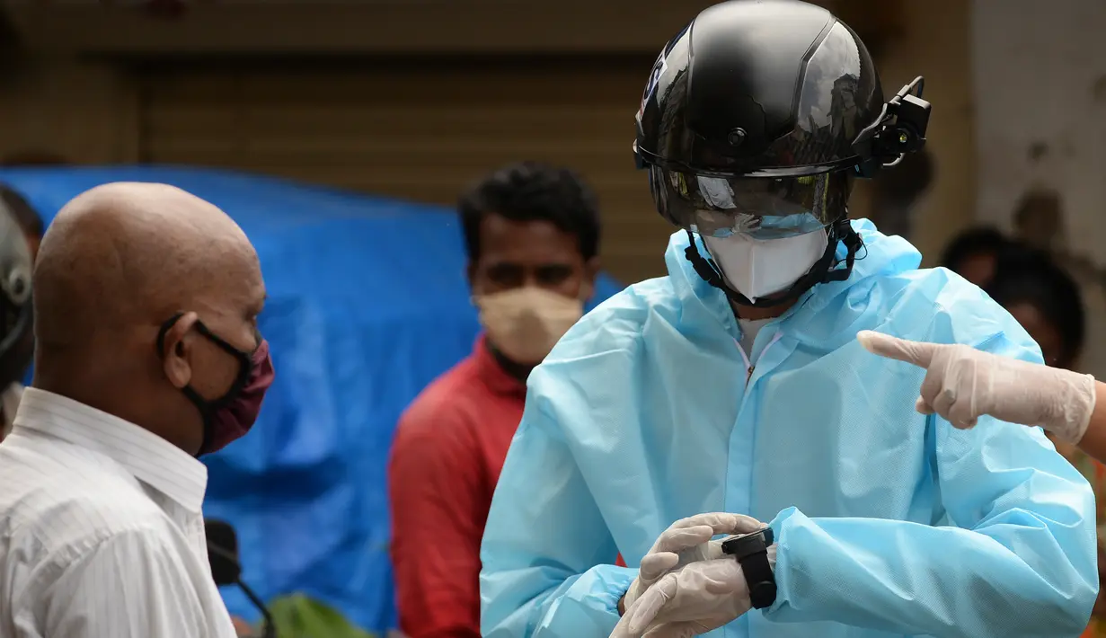 Sukarelawan petugas kesehatan dari LSM India Bharatiya Jain Sanghatana mengenakan helm pintar untuk melakukan screening kasus COVID-19 dari pintu ke pintu di Mumbai, 21 Juli 2020. Helm tersebut menjadi senjata utama bagi Mumbai dalam upaya memberantas Virus Corona. (INDRANIL MUKHERJEE/AFP)