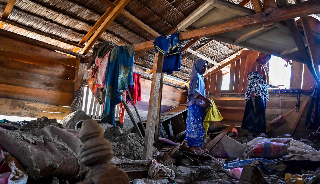 Ratusan kepala keluarga yang menjadi korban bencana banjir bandang dan tanah longsor di Kabupaten Pidie Jaya, Aceh, hingga kini masih harus bertahan di tenda-tenda darurat. Tampak dalam foto, korban selamat banjir Rauzah (kiri), seorang ibu empat anak, menyelamatkan barang-barang dari rumahnya yang rusak di Meurah Dua, Kabupaten Pidie Jaya, Provinsi Aceh, pada 21 Februari 2026, setelah banjir dan tanah longsor dahsyat melanda Sumatra, akhir November 2025 lalu. (CHAIDEER MAHYUDDIN/AFP)