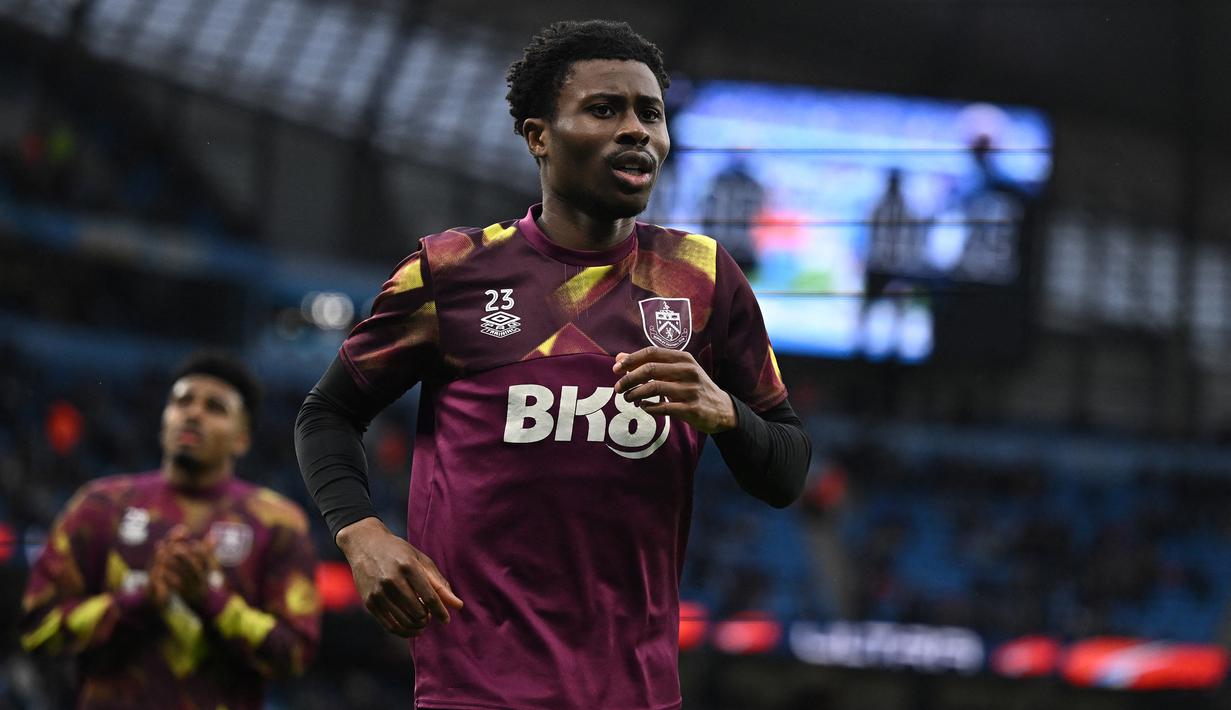 Striker Burnley, Nathan Tella melakukan pemanasan menjelang dimulainya laga perempatfinal Piala FA 2022/2023 menghadapi Manchester City di Etihad Stadium, Manchester (18/3/2023). Nathan Tella dipinjam Burnley dari Southampton pada awal musim 2022/2023. Pemain asal Inggris ini telah tampil dalam 37 laga di Championship dengan torehan 17 gol dan 5 assist. (AFP/Oli Scarff)