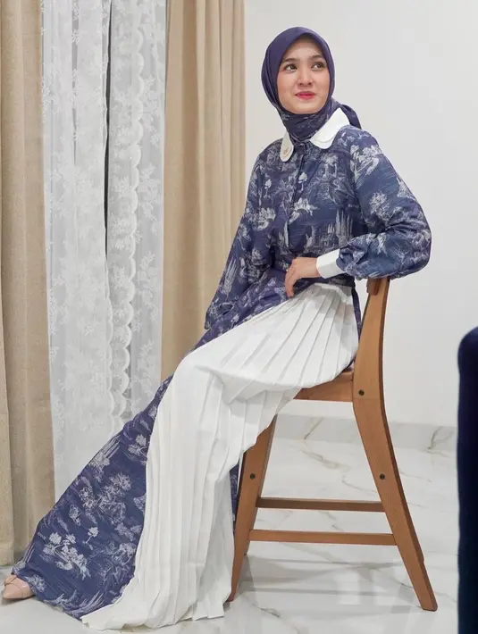 OOTD chic dari Cut Syifa yang tampil mengenakan atasan blouse berkerah super panjang bernuansa biru dengan corak floral yang cantik, dipadu mengenakan pleated pants putih dan hijab birunya yang serasi. [Foto: Instagram/cutsyifaa]