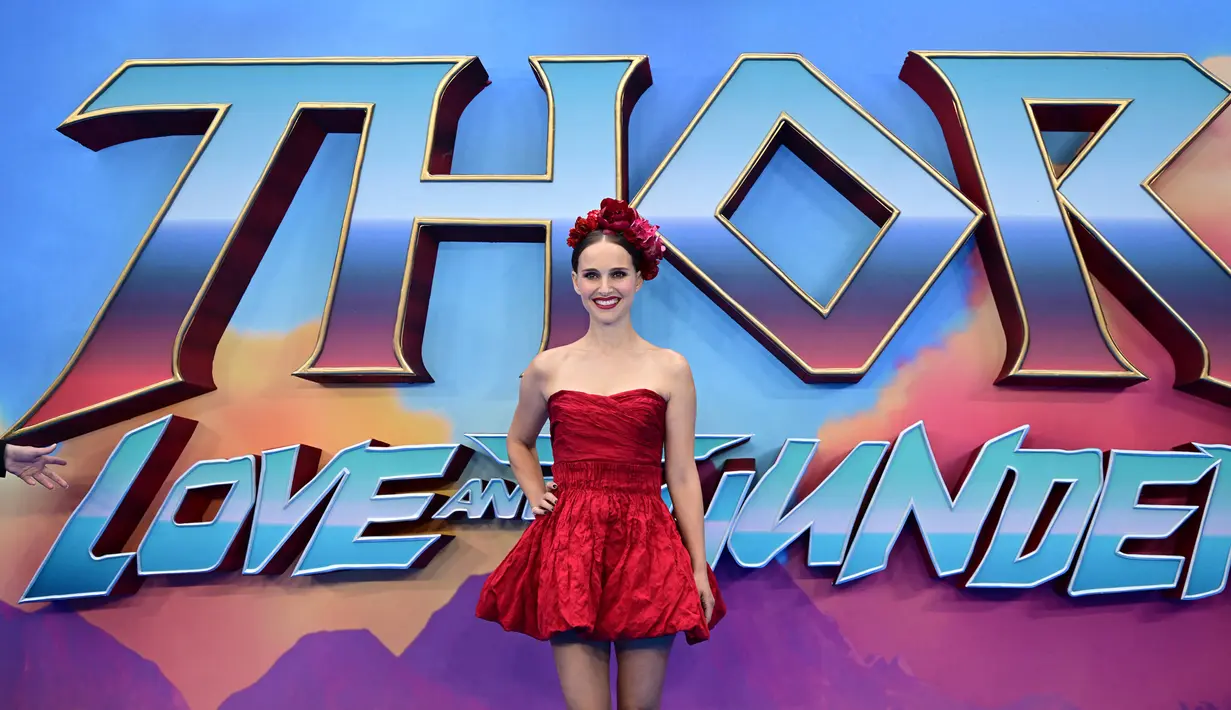 Natalie Portman berpose untuk fotografer saat tiba pada premier film Thor: Love and Thunder di London, Inggris, 5 Juli 2022. Gaun merah yang membungkus tubuh Natalie Portman tak lepas dari sorotan. (Daniel LEAL/AFP)