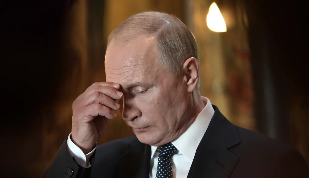 Presiden Rusia Vladimir Putin saat kebaktian di Annunciation Cathedral usai upacara pelantikan dirinya di Kremlin, Moskow, Rusia, Senin (7/5). Vladimir Putin telah berkuasa selama 18 tahun di Rusia. (Alexei Nikolsky, Sputnik, Kremlin Pool Photo via AP)