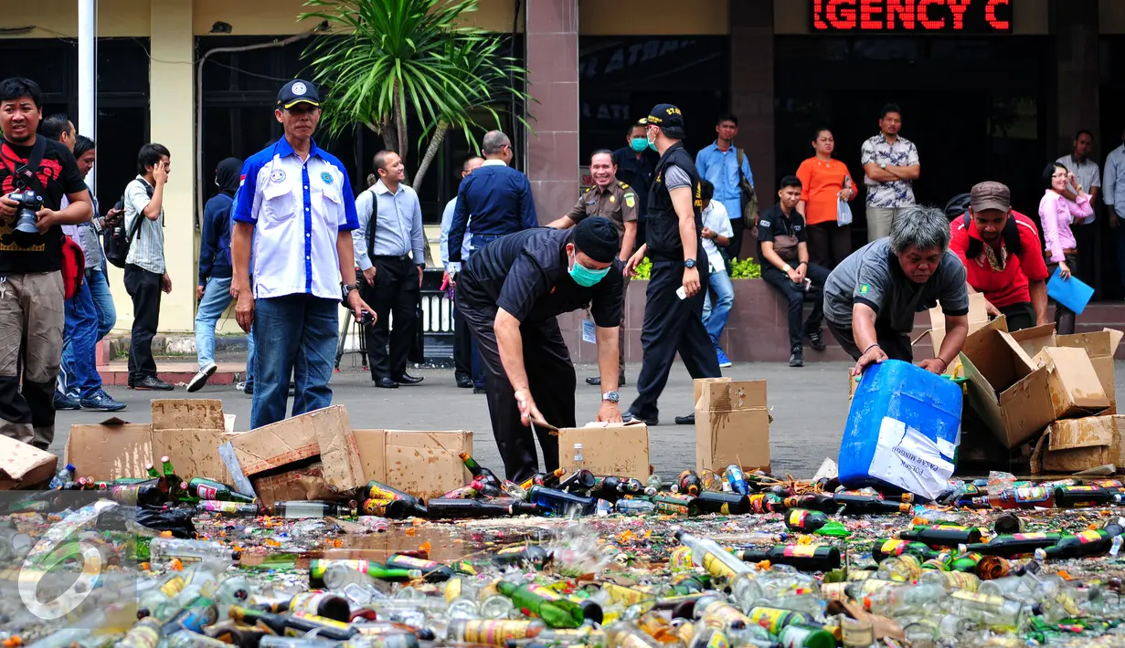Petugas memusnakan ribuan botol miras hasil operasi penyakit masyarakat (pekat) 2015 di halaman Polres Jaksel, Rabu (10/6/2015). Pemusnahan 8.000 botol miras untuk menekan peredaran miras khususnya menjelang bulan Ramadan. (Liputan6.com/Yoppy Renato)