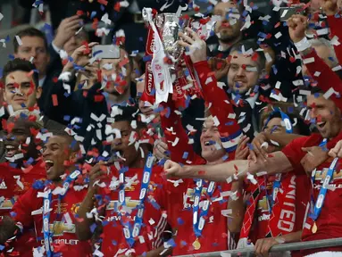 Penyerang Manchester United, Wayne Rooney mengangkat Piala Liga Inggris, setelah mengalahkan Southampton dalam pertandingan final di Stadion Wembley, London, (27/2). MU menang atas Southampton dengan skor 3-2. (AFP Photo / Ian Kington)
