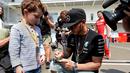 Pebalap Mercedes, Lewis Hamilton memberikan tanda tangan kepada seorang anak di area paddock Sirkuit Autodromo Hermanos Rodriguez, Mexico City, Meksiko, (29/10/2015). (AFP Photo/Alfredo Estrella)