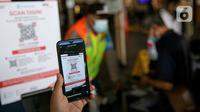 Calon penumpang KRL memindai kode batang melalui aplikasi PeduliLindungi di Stasiun Manggarai, Jakarta, Selasa (7/9/2021). PT KAI Commuter menguji coba penggunaan aplikasi PeduliLindungi bagi pengguna KRL di 11 stasiun, diantaranya Stasiun Pasar Minggu dan Bekasi Timur. (Liputan6.com/Faizal Fanani)
