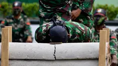 Prajurit TNI Yonif Raider 112/Dharma Jaya mematahkan pipa beton dengan kepalanya saat atraksi dalam upacara sertijab di Banda Aceh, Aceh, Rabu (18/9/2019). Mayor Inf Syarifuddin Liwang menjadi Komandan Yonif Raider 112/Dharma Jaya menggantikan Mayor Inf Agus Alfauzi. (CHAIDEER MAHYUDDIN/AFP)
