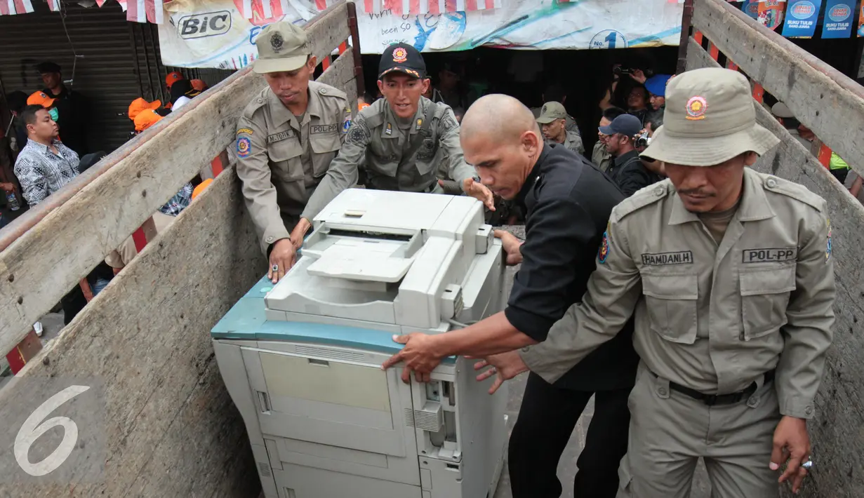Petugas Satpol PP menaikkan mesin fotokopi salah satu kios di Kavling 36 Pasar Benhil, Jakarta, (29/8/2015). Pembongkaran dilakukan berdasarkan putusan PTUN Jakarta yang memenangkan PD Pasar Jaya. (Liputan6.com/Gempur M Surya)