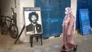 Warga melintas di depan poster Jimi Hendrix kota pesisir Maroko Essaouira pada 10 September 2020. Catatan sejarah mengungkap bahwa Hendrix wafat akibat tersedak muntahannya sendiri di sebuah hotel di London pada 18 September 1970 setelah menelan pil tidur dan minum anggur merah. (AFP/Fadel Senna)
