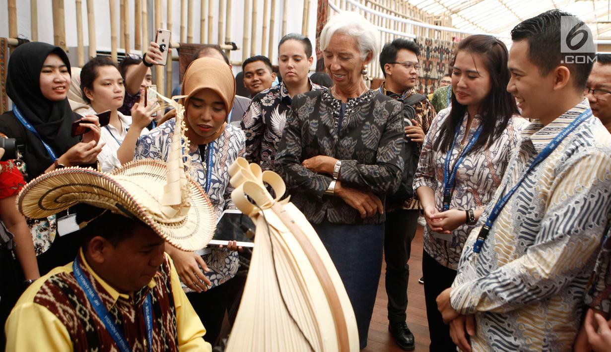 Managing Director IMF Christine Lagarde menyaksikan musikus memainkan sasando saat berkunjung ke Paviliun Indonesia di arena pertemuan IMF-Bank Dunia, Bali, Rabu (10/10). Christine terpesona dengan berbagai budaya Nusantara. (Liputan6.com/Angga Yuniar)