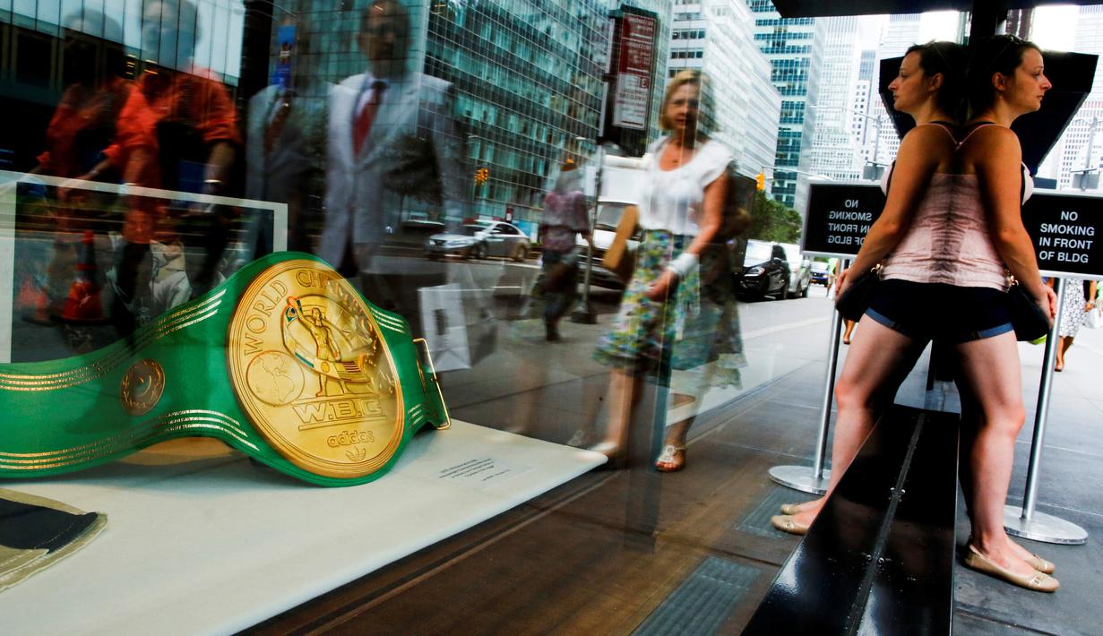 Warga melintas di dekat etalase tempat barang-barang Muhammad Ali dipajang di Heritage Auctions, Manhattan, New York, AS, (19/8). (REUTERS/Eduardo Munoz)