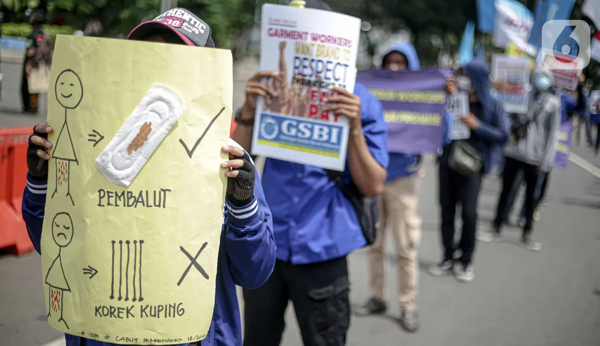 Massa Gabungan Serikat Buruh Indonesia (GSBI) membawa pembalut wanita saat berunjuk rasa di kawasan Patung Kuda, Jakarta, Senin (16/11/2020). GSBI meminta pemerintah mencabut UU Cipta Kerja serta menaikkan upah buruh 2021 sesuai kebutuhan rill buruh dan keluarga. (Liputan6.com/Faizal Fanani)