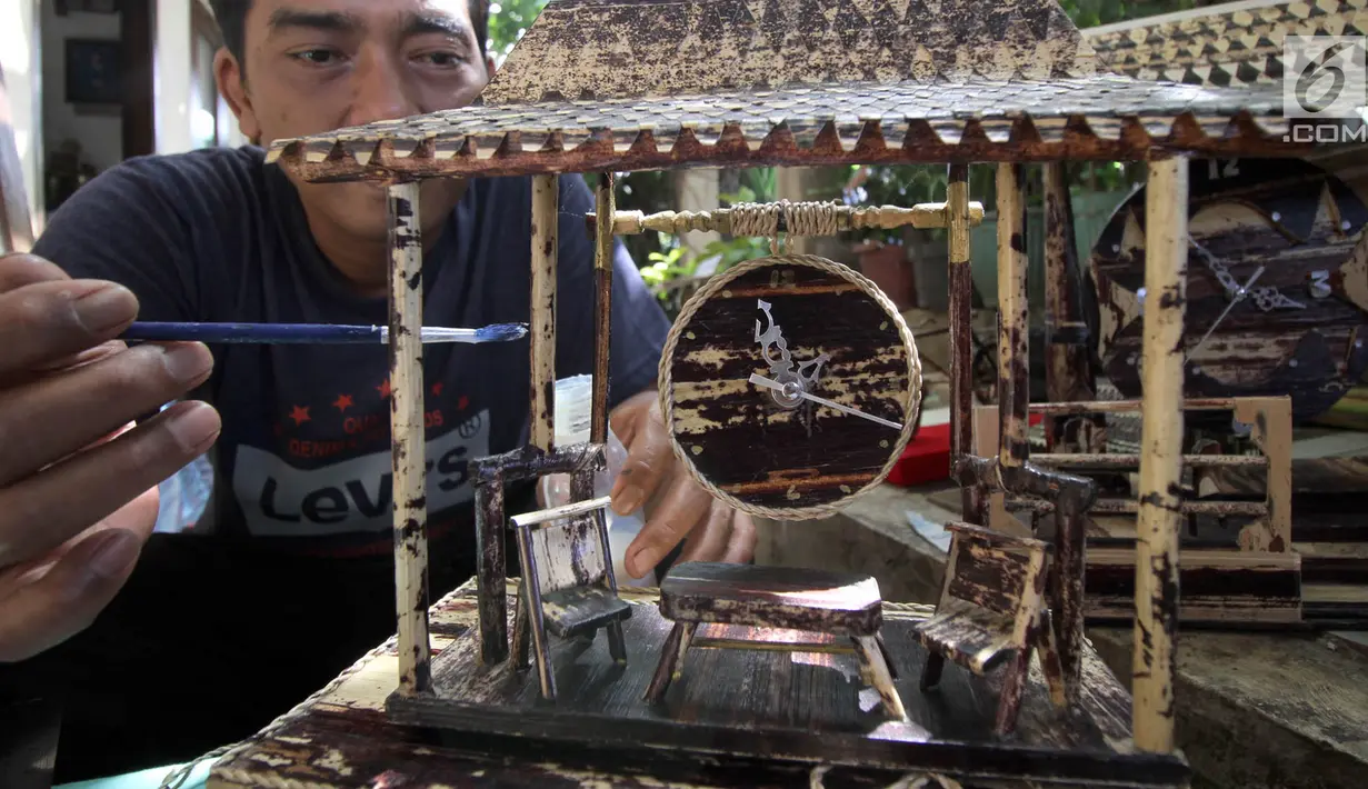 Perajin, Inoe Farhand menyelesaikan pembuatan miniatur jam dari pelepah pisang di Pamulang, Tangsel, Kamis (10/1). Dalam sehari Inoe mampu menyelesaikan dua buah kerajinan tangan seperti miniatur becak, mobil VW dan Kapal phinisi (Merdeka.com/Arie Basuki)