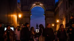 Orang-orang menunggu menyeberang jalan di Rua Augusta Arch di Lisbon (17/12). Penduduk kota ini berjumlah 600.000 jiwa dan di daerah metropolitan sekitar 2,5 juta jiwa. Jumlah ini kira-kira 1/3 penduduk Portugal. (AFP Photo/Patricia De Melo Moreira)