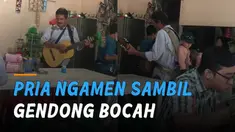Seorang pria ngamen sambil menggendong bocah di belakang punggungnya mengundang perhatian.