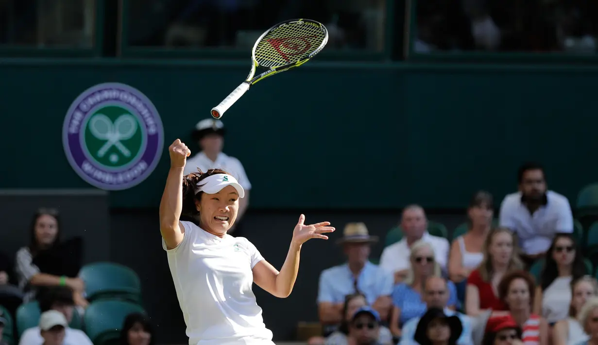 Petenis asal Jepang, Kurumi Nara kehilangan kendali atas raketnya setelah mengembalikan bola pukulan Petenis Rumania Simona Halep saat bertanding pada hari kedua tunggal putri Kejuaraan Tenis Wimbledon di London, (3/7). (AP Photo / Ben Curtis)