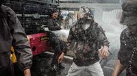 Pihak kepolisian yang berjaga berusaha membubarkan massa tersebut dengan menembakkan gas air mata ke arah pengunjuk rasa. (YASUYOSHI CHIBA/AFP)