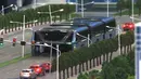 Sebuah model bus besar mengangkangi sejumlah mobil di sebuah pameran di Beijing, Cina, (20/5). Bus ini akan di uji pada tahun 2017 yang diharapkan dapat mengatasi kemacetan lalu lintas. (Youtube/New China TV)