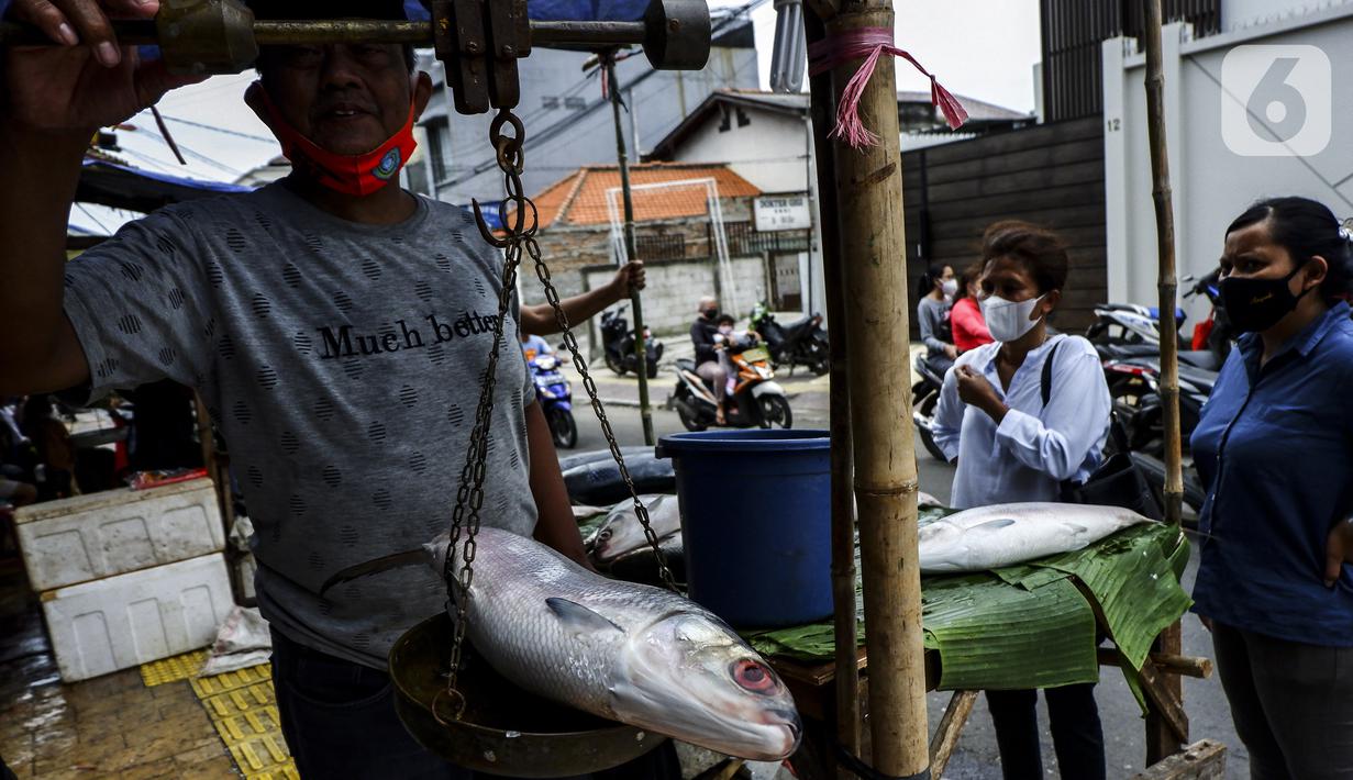 Pedagang menimbang ikan bandeng saat melayani pembeli di kawasan Rawa Belong, Jakarta Barat, Rabu (10/2/2021). Jelang Tahun Baru Imlek 2021, para pedagang ikan bandeng mulai bermunculan di Rawa Belong. (Liputan6.com/Johan Tallo)
