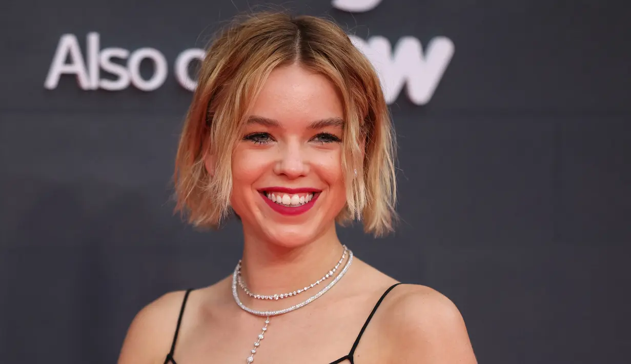 Aktris Australia Milly Alcock tersenyum saat berpose di karpet merah saat tiba untuk menghadiri pemutaran perdana serial drama asli HBO "House of the Dragon" di Leicester Square Gardens, di London (15/8/2022). (AFP/Hollie Adams)