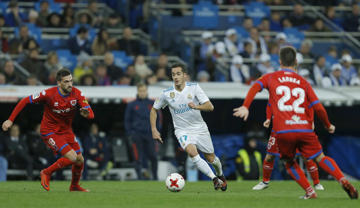 Aksi pemain Real Madrid, Lucas Vazquez (tengah) menerobos pertahanan Numancia pada laga Copa Del Rey di Santiago Bernabeu stadium, Madrid, (10/01/2018). Real Madrid unggul agregat 5-2 atas Numancia. (AP/Francisco Seco)