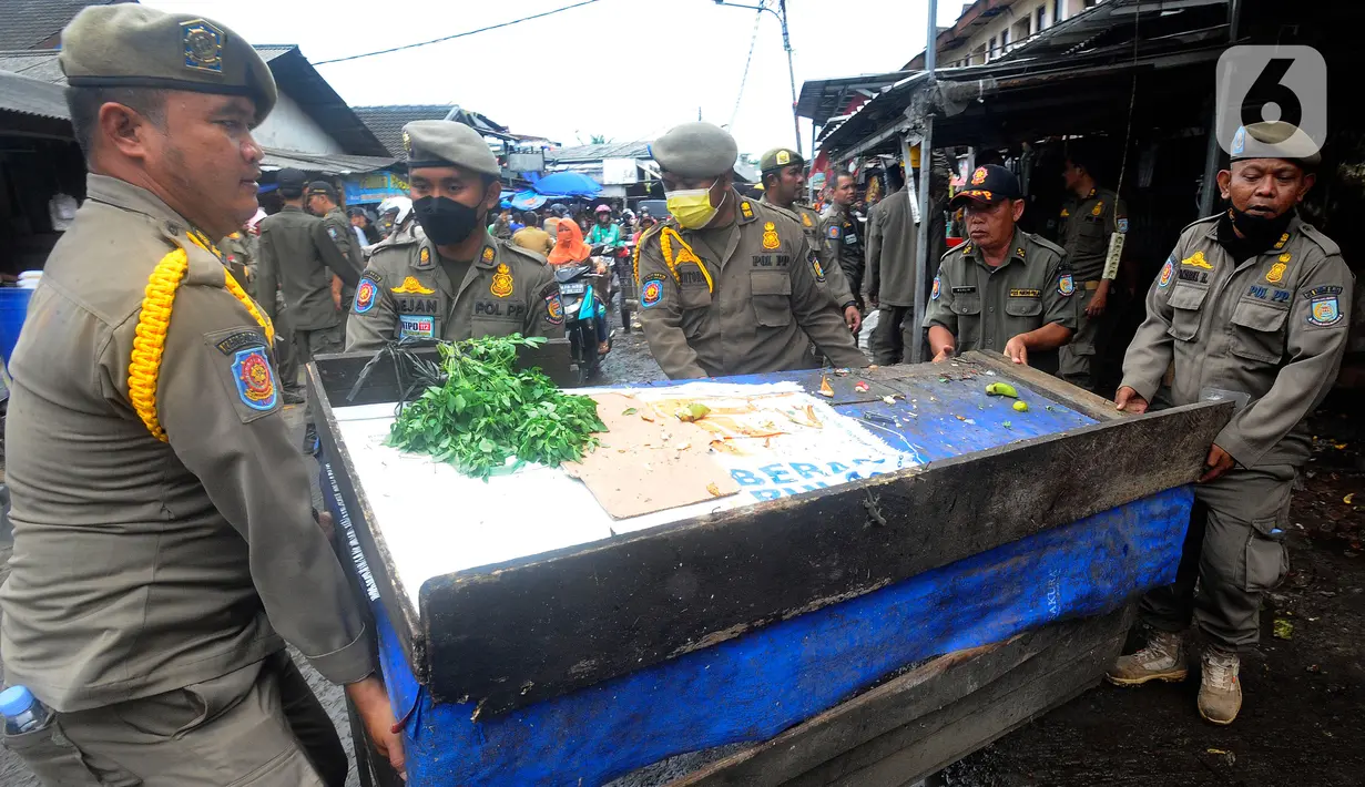 Petugas Satuan Polisi Pamong Praja (Satpol PP) Kota Tangerang Selatan memindhkan lapak pedagang kaki lima (PKL) di luar area Pasar Ciputat, Tangerang Selatan, Banten, Selasa (14/2/2023). Penertiban ini ditujukan untuk puluhan lapak PKL di sekitar Jalan Aria Putera, Jalan H. Usman, Jalan Bancet, dan kawasan Polikarbonat karena keberadaannya mengganggu ketertiban umum di antaranya kemacetan lalu lintas. (merdeka.com/Arie Basuki)