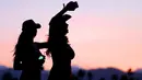 Dua wanita seksi bernyanyi dan berjoged menggunakan topi koboi saat menghadiri Festival musik Country Stagecoach di Empire Polo Club di Indio, California, 29 April 2016. (AFP PHOTO/Jason Kempin)