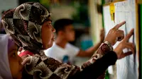 Salah satu pemilik hak suara mengecek namanya dalam referendum pembentukan daerah otonomi Bangsa Moro di Mindanao, Filipina (21/1) (AFP PHOTO)