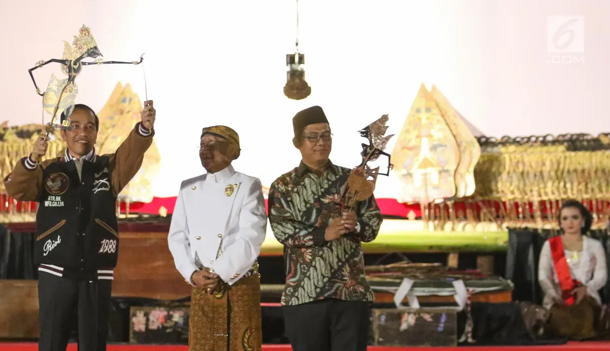 Presiden Joko Widodo (Jokowi) memainkan wayang kulit disaksikan dalang Ki Mantep Sudarsono (tengah) dalam Pagelaran Wayang Kulit 74 Tahun Indonesia Merdeka di halaman depan Istana Merdeka, Jakarta, Jumat (2/8/2019). Pagelaran wayang mengangkat tema "Kresno Jumeneng Ratu”.(Liputan6.com/Angga Yuniar)