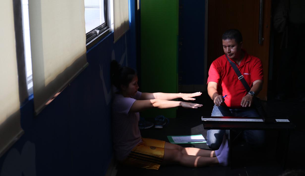 Seorang atlet Angkat Besi Indonesia, sedang mengikuti instruksi saat melakukan test Sport Science sebagai persiapan menuju Olympiade Rio De Jeneiro 2016 di Gedung PP ITKON, Jakarta, Kamis (07/01/2016). (Bola.com/Nicklas Hanoatubun)