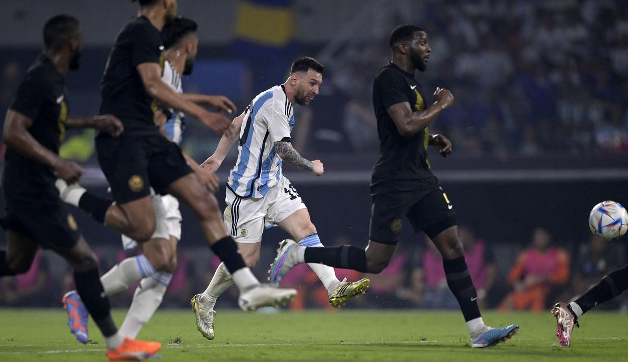 Pemain Timnas Argentina, Lionel Messi mengumpan bola bola pada laga uji coba internasional melawan Curacao yang berlangsung di Stadion Unico Madre de Ciudades, Rabu (29/3/2023) pagi WIB. La Pulga berhasil mencetak hattrick dan membawa timnya menang dengan skor 7-0. (AFP/Juan Mabromata)