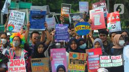 Massa aktivis lingkungan hidup melakukan protes di Kawasan Monas, Jakarta, Jumat, (3/3/2023). Aksi ini juga menuntut  untuk menghentikan proyek-proyek solusi palsu yang membawa  Indonesia tetap terjebak pada candu energi fosil batubara.  (merdeka.com/Imam Buhori)