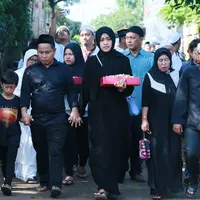 Dengan mengenakan pakaian hitam-hitam, Narji didampingi anak pertamanya dan istrinya beserta kerabatnya mengantarkan ayahnya ke peristirahatan terakhirnya di TPU Poncol tadi pagi. (Adrian Putra/Bintang.com)