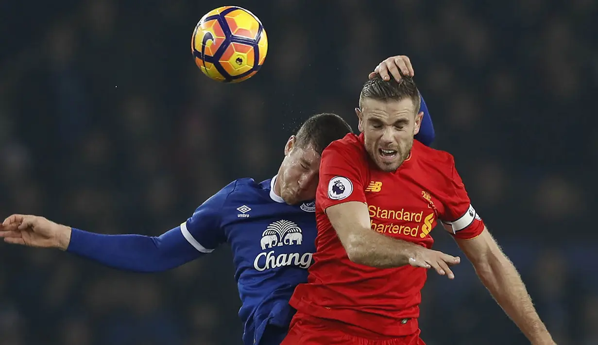 Gelandang Liverpool, Jordan Henderson, duel udara dengan gelandang Everton, Ross Barkley. Meski bermain tandang, Liverpool lebih menguasai jalannya laga dengan penguasaan bola mencapai 64 persen. (Reuters/Phil Noble)