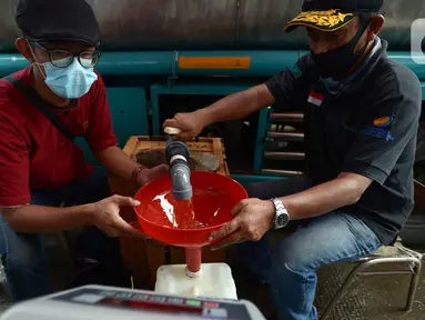 Distribusi minyak goreng curah di Pasar Perumnas, Jumat (25/2/2022). Menteri Perdagangan Muhammad Lutfi meminta distributor minyak goreng lebih cepat memasok minyak goreng curah ke pasar. (merdeka.com/Imam Buhori)