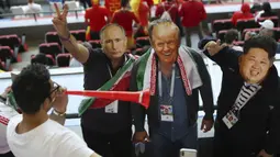 Suporter Iran memakai topeng wajah dari Donald Trump, Vladimir Putin dan Kim Jong-un saat menonton laga grup B Piala Dunia melawan Spanyol di Kazan Arena, Kazan, Rabu (20/6/2018). Iran kalah 0-1 dari Spanyol. (AP/Eugene Hoshiko)