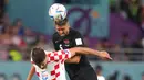Pemain Kanada Steven Vitoria (5) menyundul bola melewati pemain Kroasia Bruno Petkovic (16) pada pertandingan sepak bola Grup F Piala Dunia 2022 di Stadion Internasional Khalifa, Al Rayyan, Qatar, 27 November 2022. Kroasia mengalahkan Kanada dengan skor 4-1. (Nathan Denette/The Canadian Press via AP)