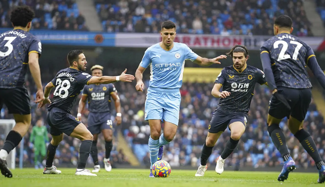 <p>Pemain Manchester City&nbsp;Rodri (tengah) menggiring bola melewati para pemain Wolverhampton Wanderers pada pertandingan sepak bola Liga Inggris di Etihad Stadium, Manchester, Inggris, 11 Desember 2021. Manchester City menang 1-0. (AP Photo/Dave Thompson)</p>