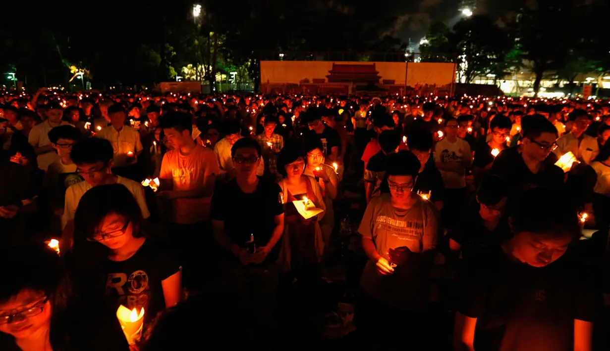 Di depan gambar lapangan Tiananmen di Victoria Park, Hong Kong (4/6/2014), ribuan orang menyalakan lilin mengenang 25 tahun tragedi penumpasan gerakan pro demokrasi oleh militer Tiongkok. (REUTERS/Bobby Yip) 