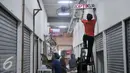 Pedagang memasang papan nama kiosnya di Tempat Penampungan Sementara (TPS), Manggarai, Jakarta, Selasa (4/10). Pedagang Pasar Rumput mulai tempati kios TPS Pasar Jaya Manggarai. (Liputan6.com/Yoppy Renato)