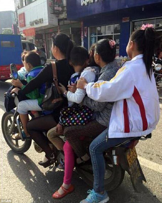 Seorang wanita membonceng 5 anak dan 1 orang pensiunan dengan 1 motor di jalan raya | Photo: Copyright dailymail.co.uk